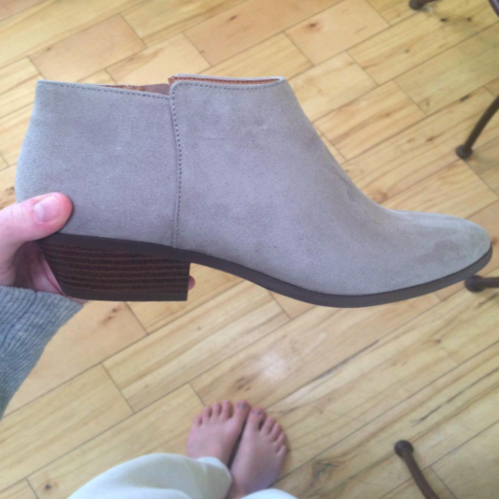 A customer review photo of a person holding the ankle booties in tan