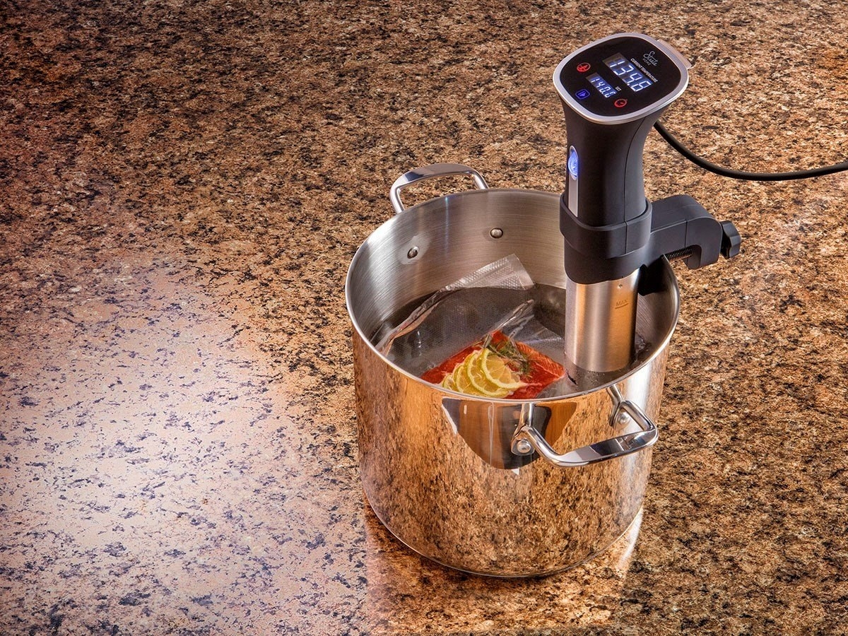 The sous vide in a pot with water and a vacuum-sealed bag of food