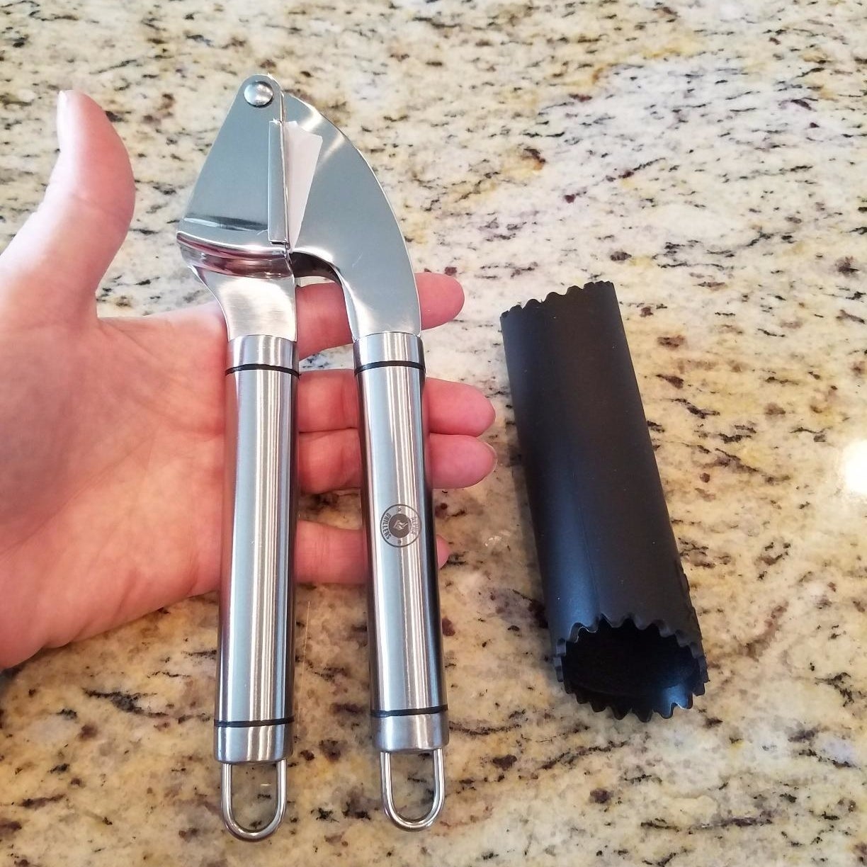 A reviewer holding the garlic press