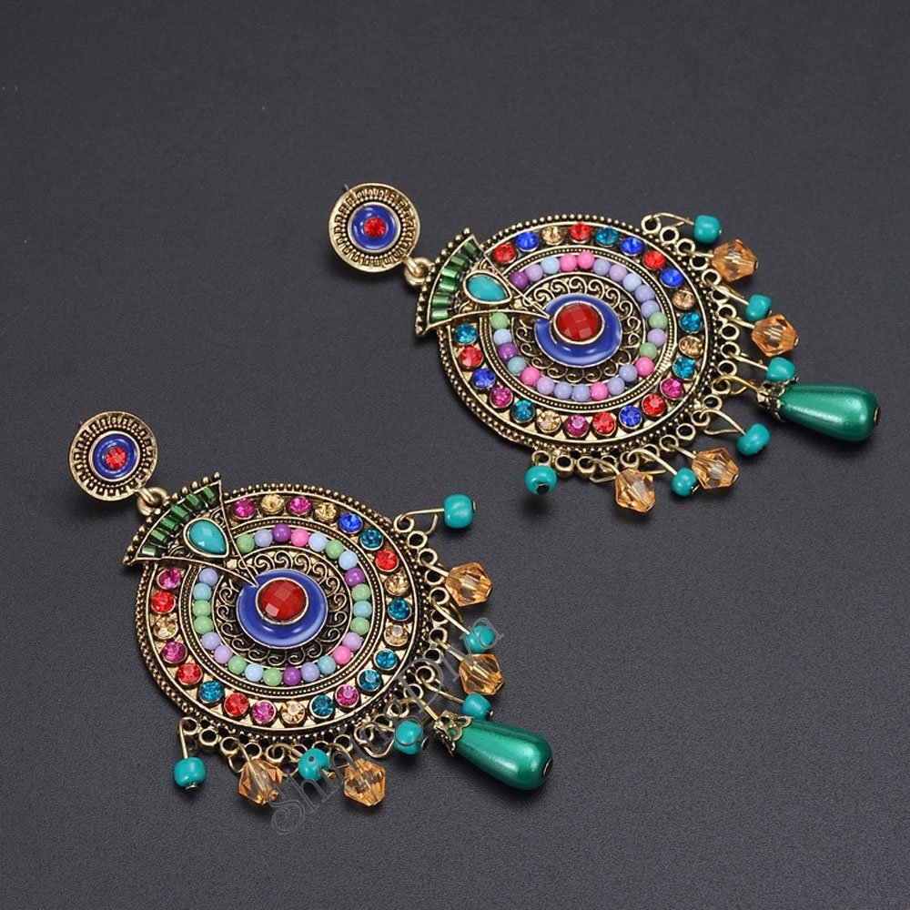 A pair of colourful earrings against a grey background