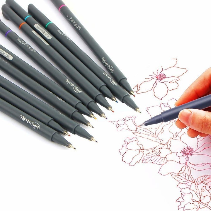the pen set and a person using one of the pens