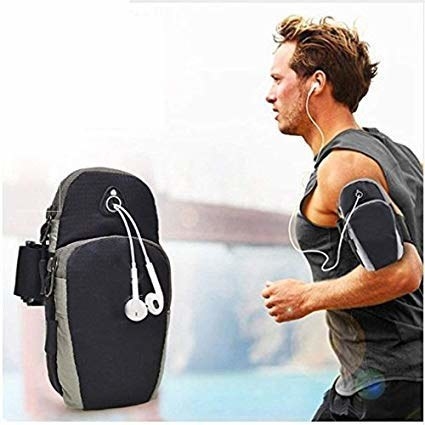 A man wearing an armband pouch and jogging. He&#x27;s wearing earphones attached to a phone inside the pouch