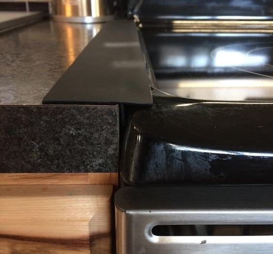 Reviewer&#x27;s picture of the gap cover placed between their stove and counter 