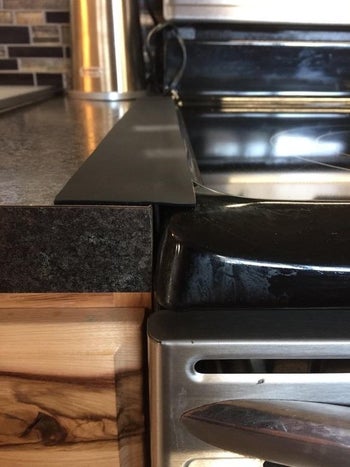 A reviewer's photo of the black gap cover used alongside their stove