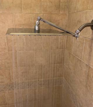 Reviewer image of the shower head with rain-like water pouring out of it