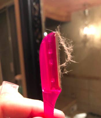 A reviewer's close up of the facial and eyebrow razor