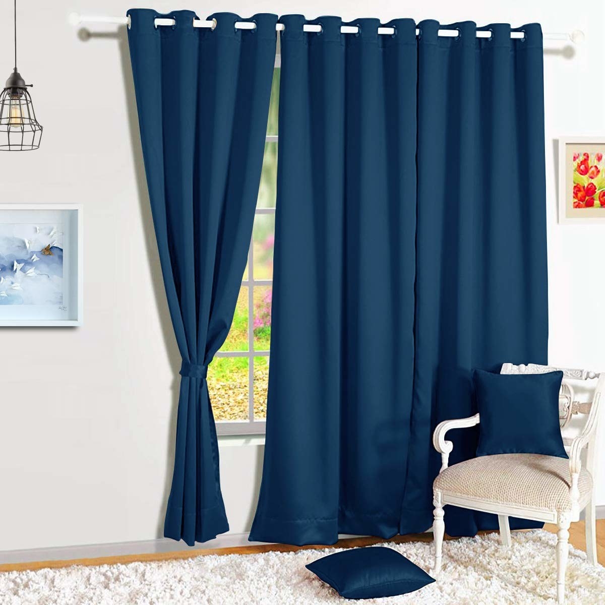 Blue full length blackout curtains in front of a window in a bedroom