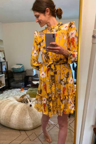reviewer wearing the yellow floral print with ruffles on shoulders