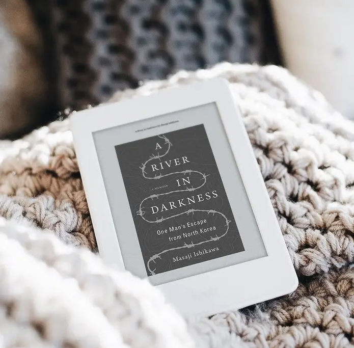 A small eReader on a knit blanket