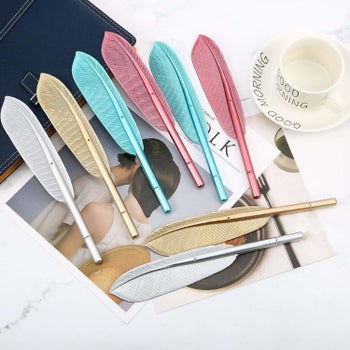 The metallic feather-shaped pens in pink, teal, gold, and silver