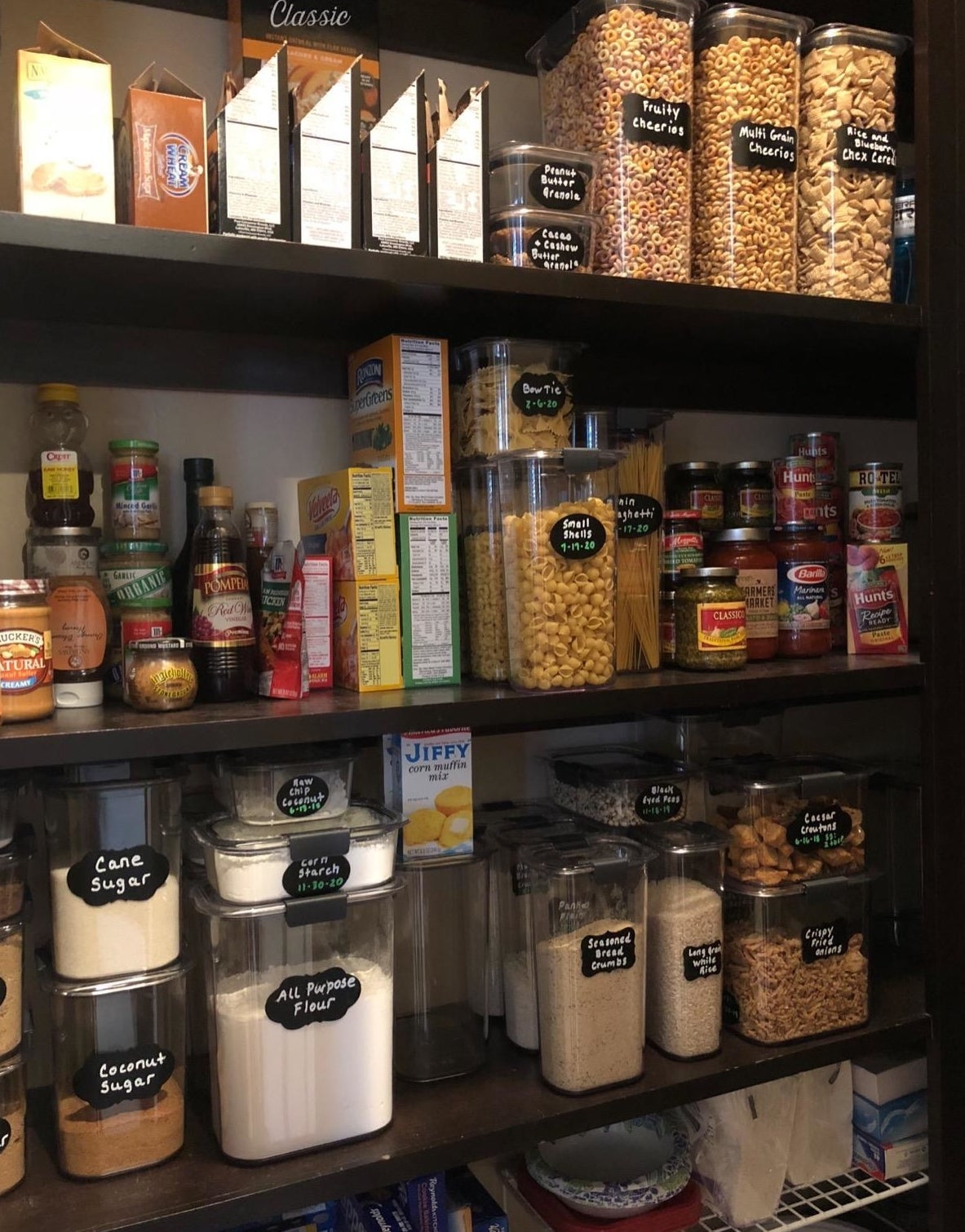 reviewer photo of a pantry organized with about twenty labeled containers