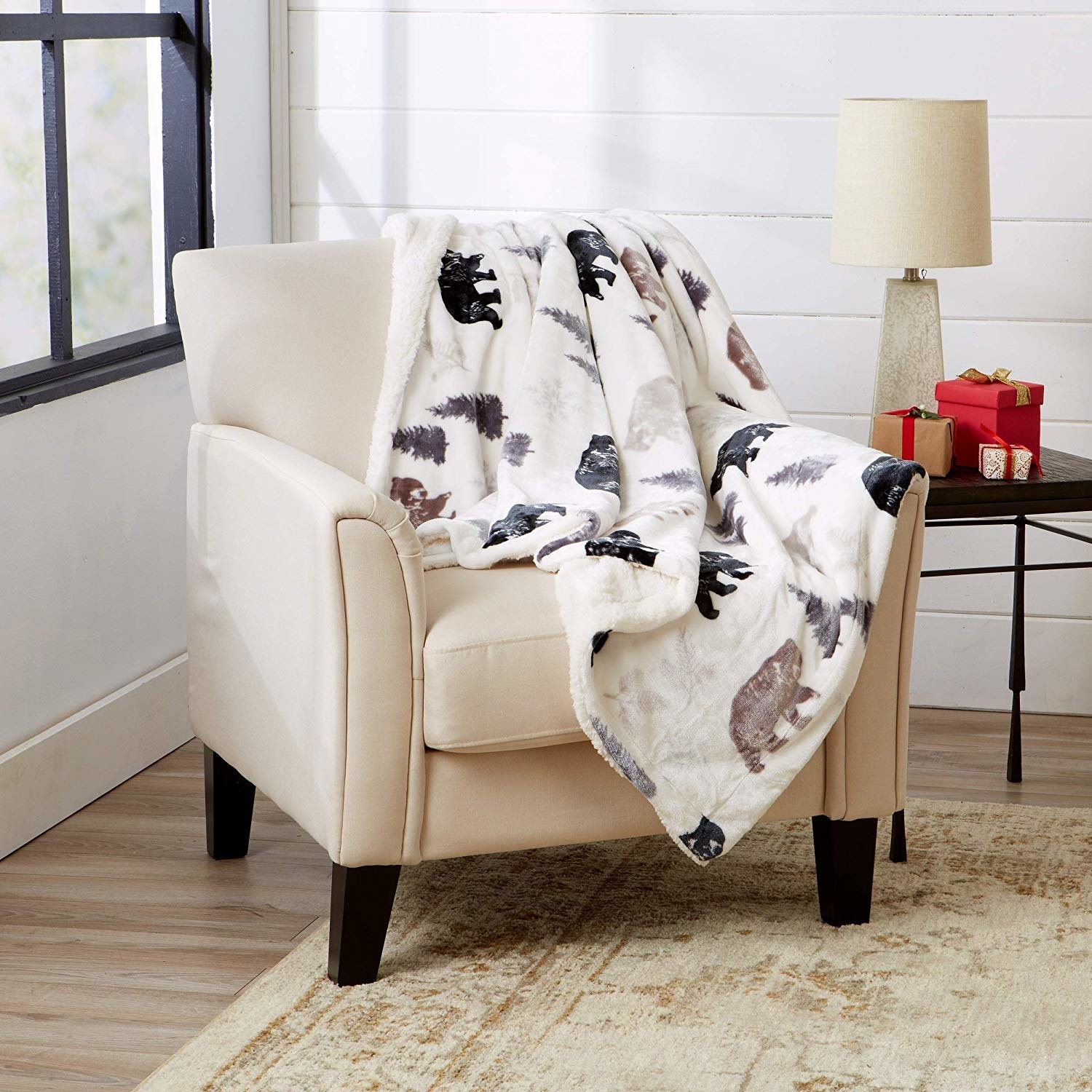 a white fuzzy blanket with bears on it draped over a chair 
