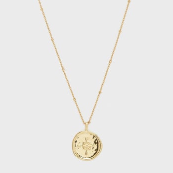 the gold necklace with a pendant that looks like a compass