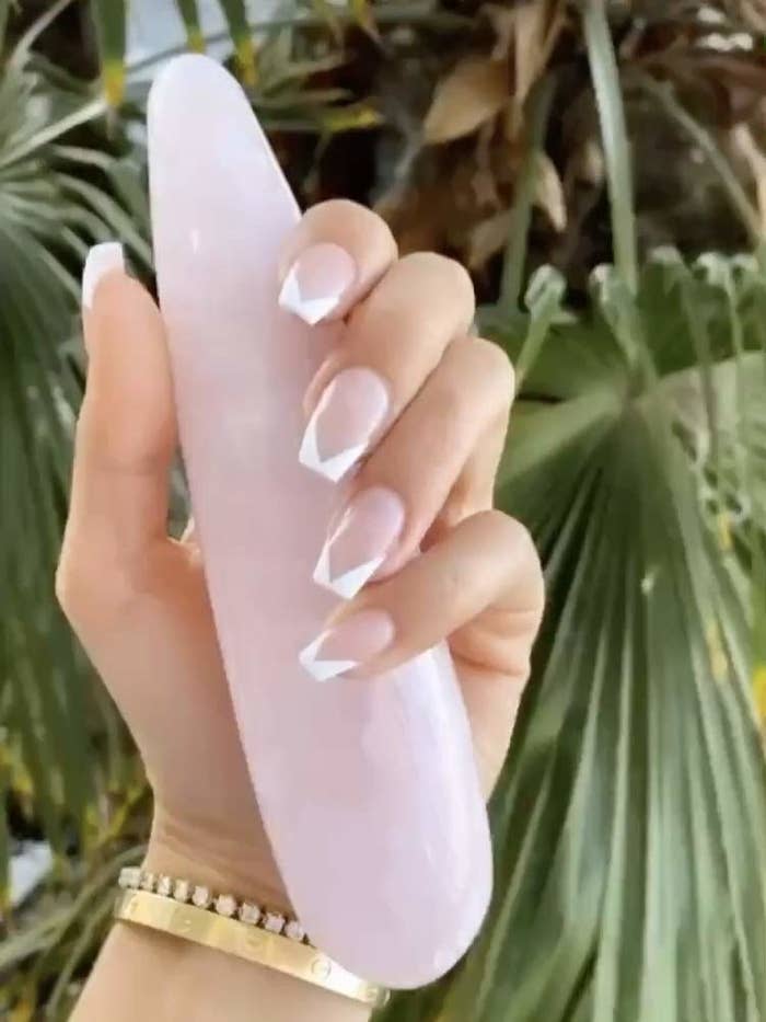 A smooth crystal massage wand with one tapered and one bulbous end, both are rounded 