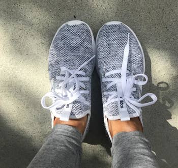 Reviewer wearing the sneakers in grey with white laces outside