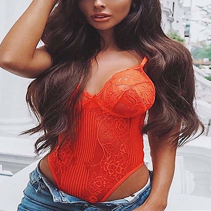 A model wearing the bodysuit with jeans in orange