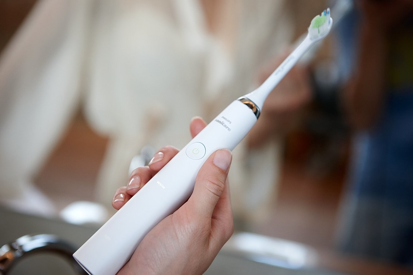 A person holding the electric toothbrush
