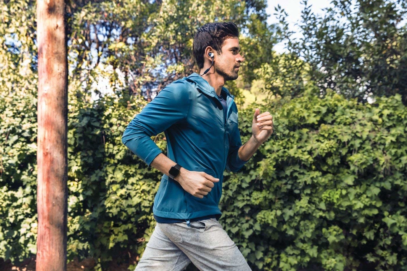A person jogging while wearing the Fitbit Versa watch on their wrist