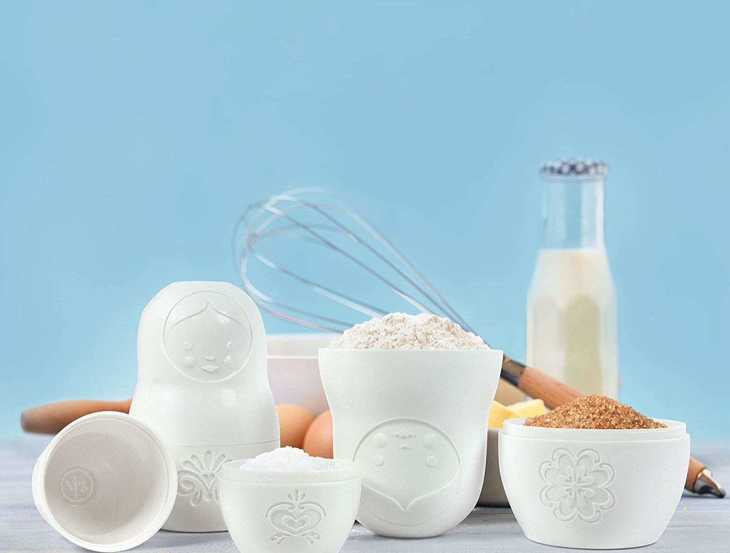 A set of nesting doll measuring cups filled with dry ingredients