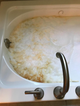 reviewer's pic of a jacuzzi style tub with lots of dirty foam in it