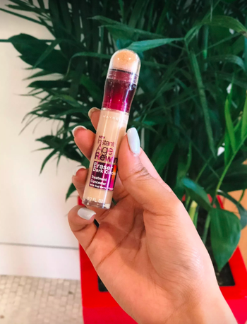 a buzzfeed editor holding the concealer stick