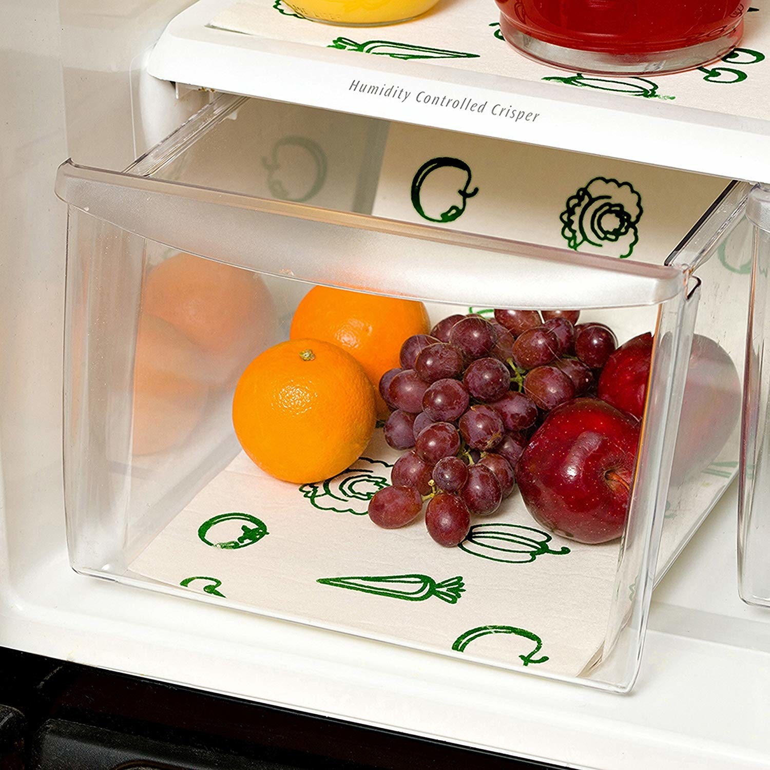 open fridge with drawer inside that has the liner underneath oranges, grapes, and apples