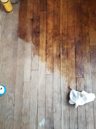 reviewer pic of a worn wood floor with about half of it looking refreshed and back to life thanks to the polish