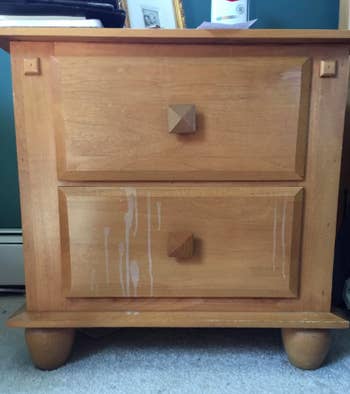 reviewer's pic of light wood nightstand with white stain drips down the front