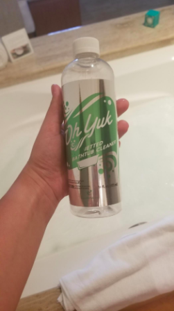 reviewer's hand holding the bottle of cleaner