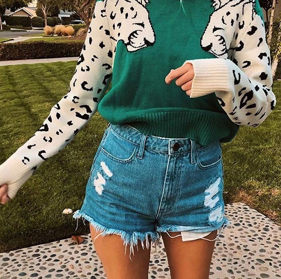 model wears leopard sweater with distressed denim