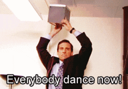 A GIF of a person holding up a speaker and saying everybody dance now