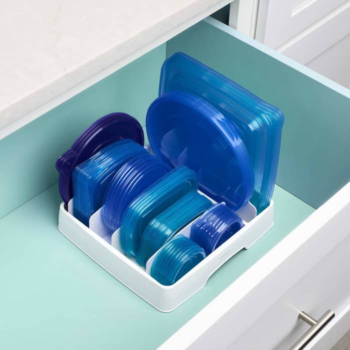 The lid organizer placed inside a kitchen drawer