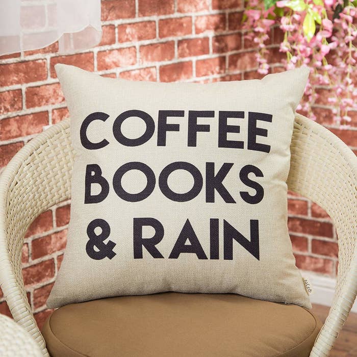 square pillow in beige with the words &quot;Coffee Books &amp;amp; Rain&quot; written on it in black