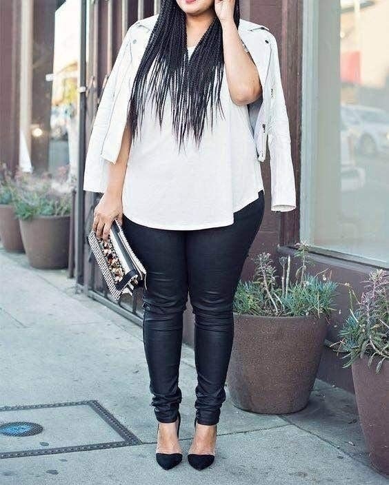 reviewer wearing faux leather leggings with white top and black heels 