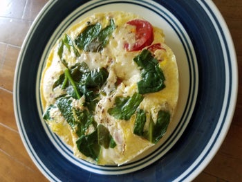 reviewer photo of their omelette with spinach and tomatoes