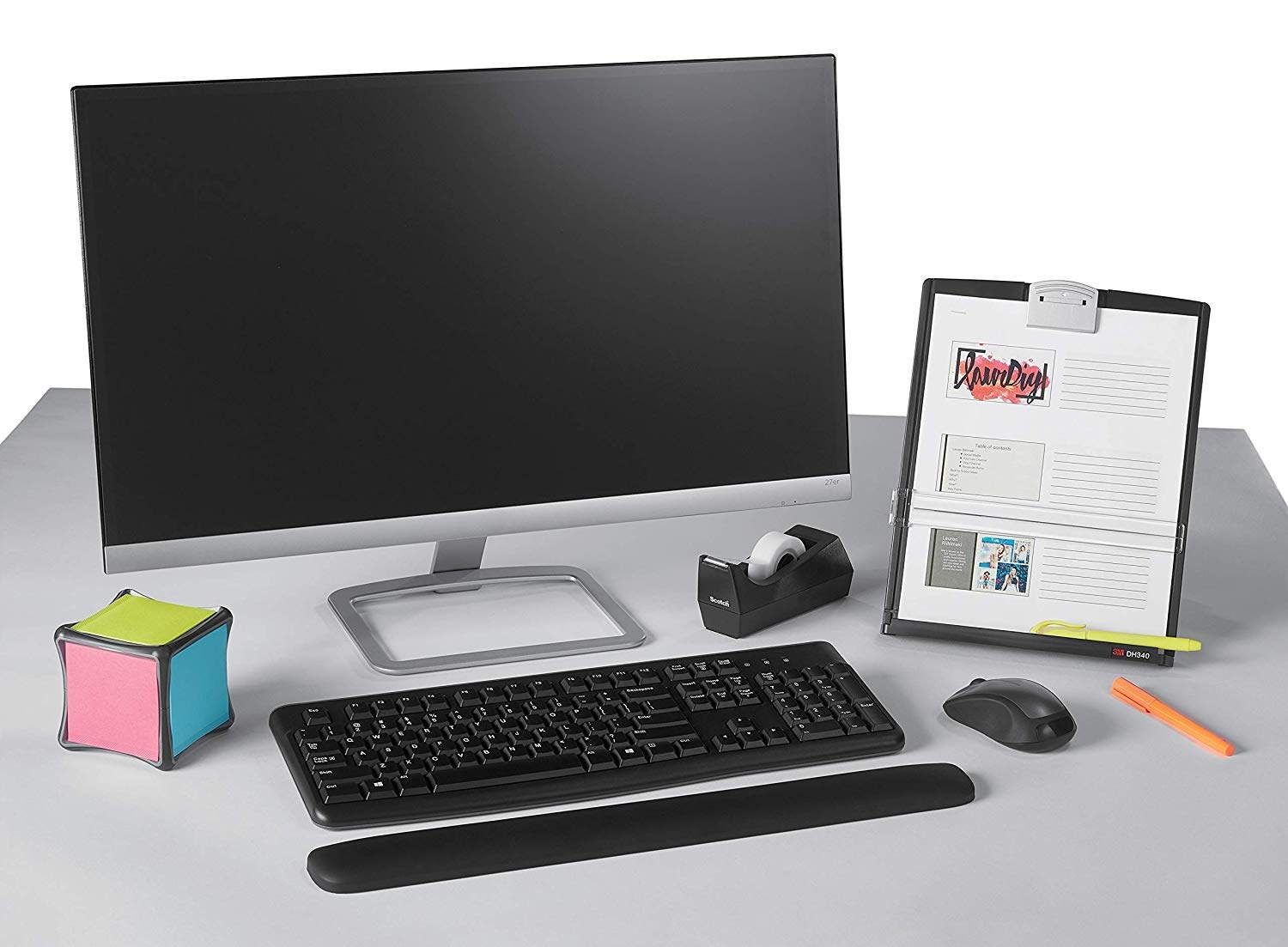 A clipboard next to a desktop computer on a table