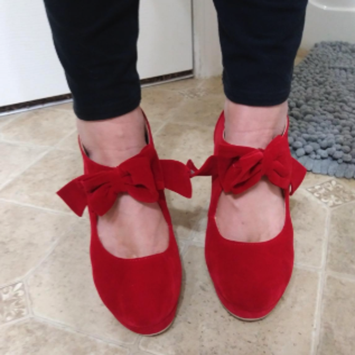 a close up on the red shoes to show the bow around the ankles