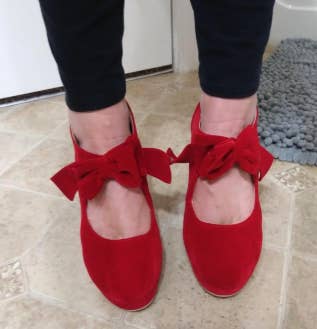 a close up on the red shoes to show the bow around the ankles