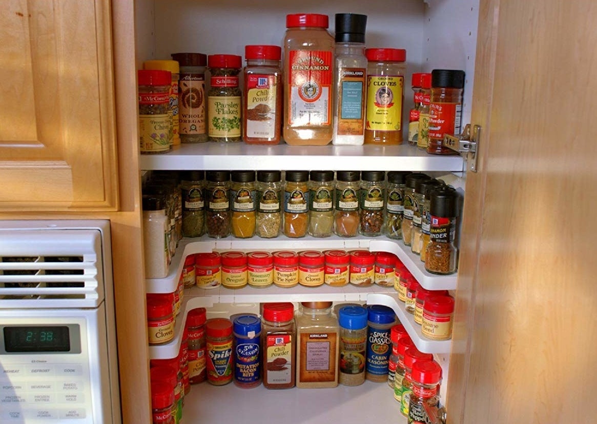 The U-shaped rack placed inside a cabinet with spices neatly organized on top of it