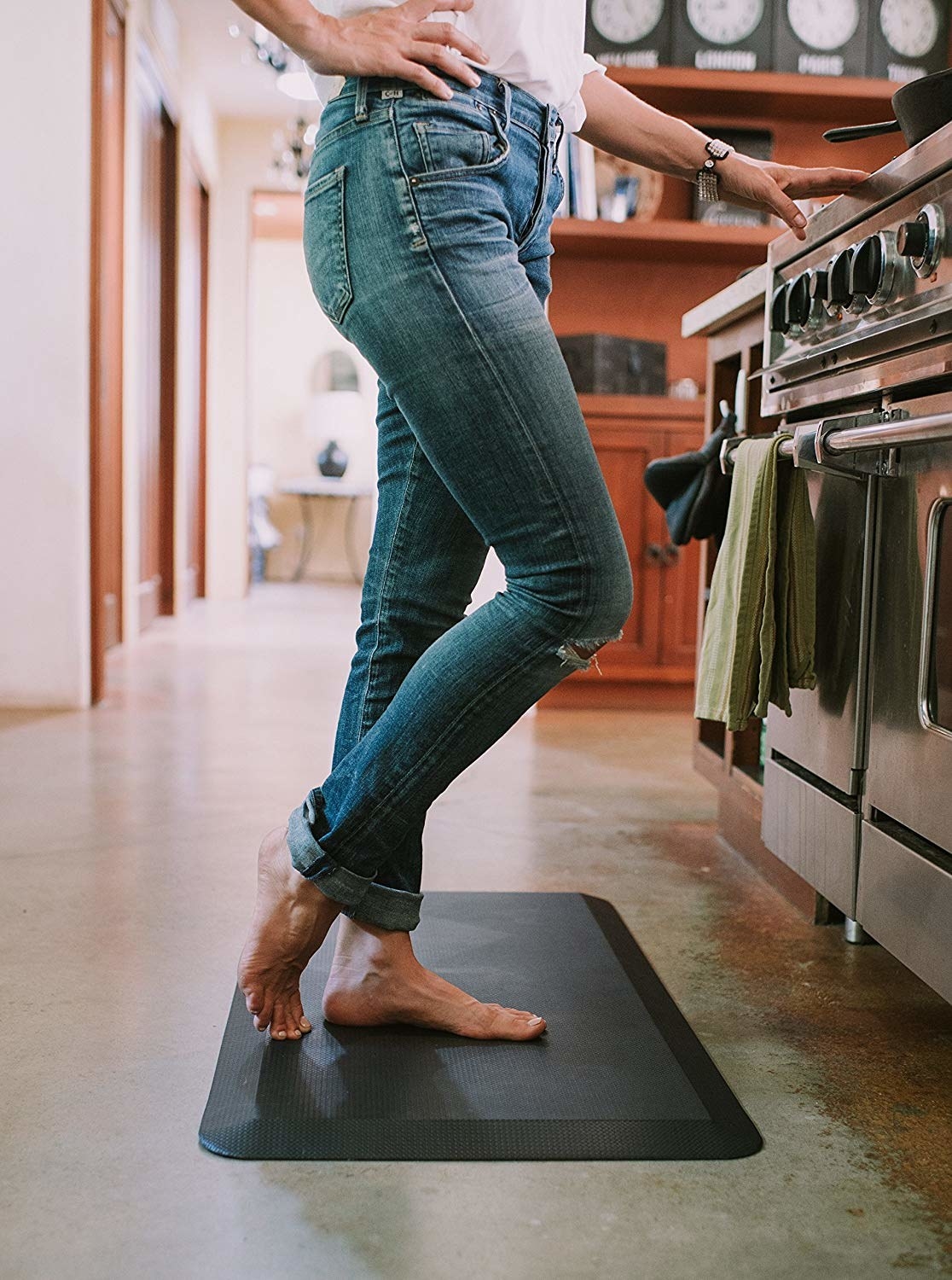 model stands bare-footed on black anti-fatigue mat