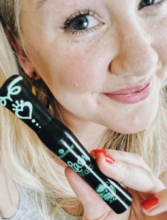 a reviewer holding the black tube of mascara