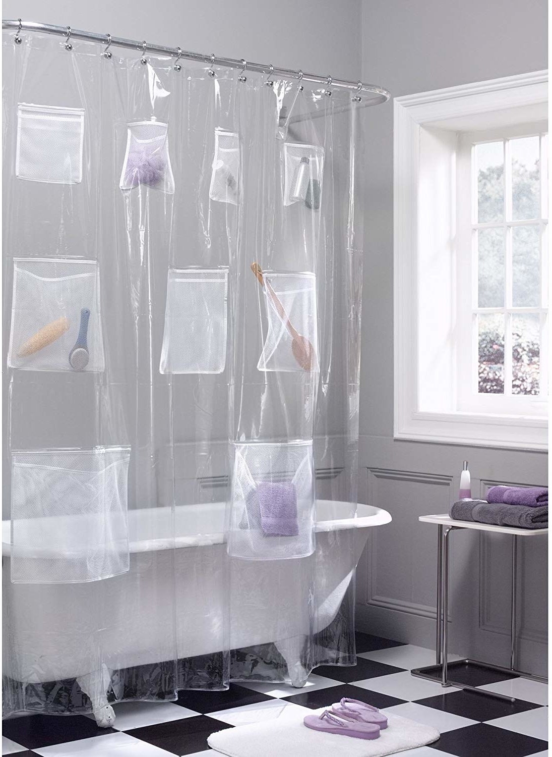 The shower curtain hung in a neat bathroom and filled with brushes, towels, and hair products