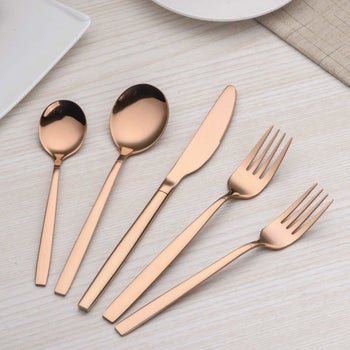 two spoons, a knife, and two forks in rose gold