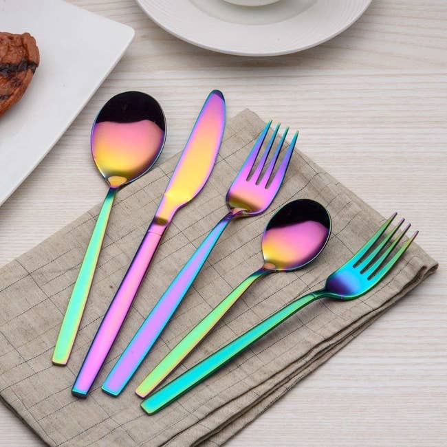 two spoons, a knife, and two forks in rainbow colored