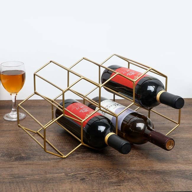 A geometric beehive shaped gold wine holder with room for seven bottles 