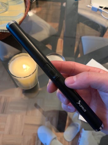 same reviewer showing candle lit in the background while holding the candle lighter