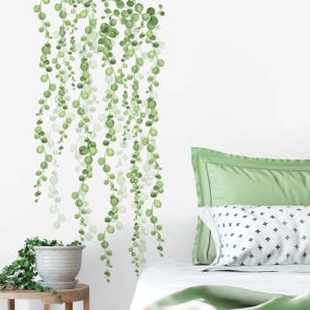 Green wall decal mimicking vines descending down a wall 