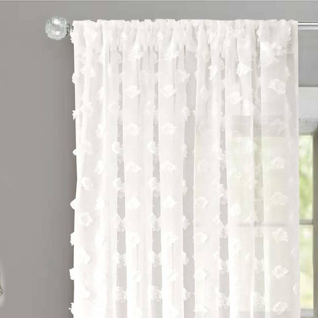 Sheer white curtains with tufted polka dot details 