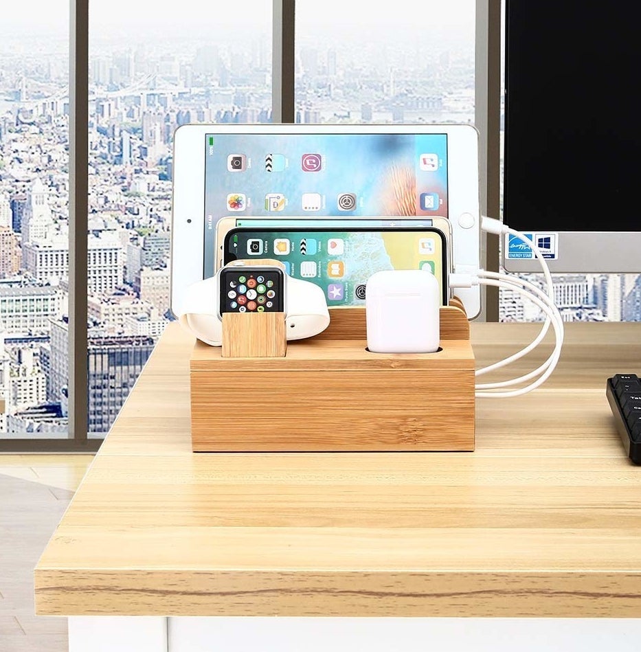 A bamboo station with slots for apple watch, airpods, phone, tablet 