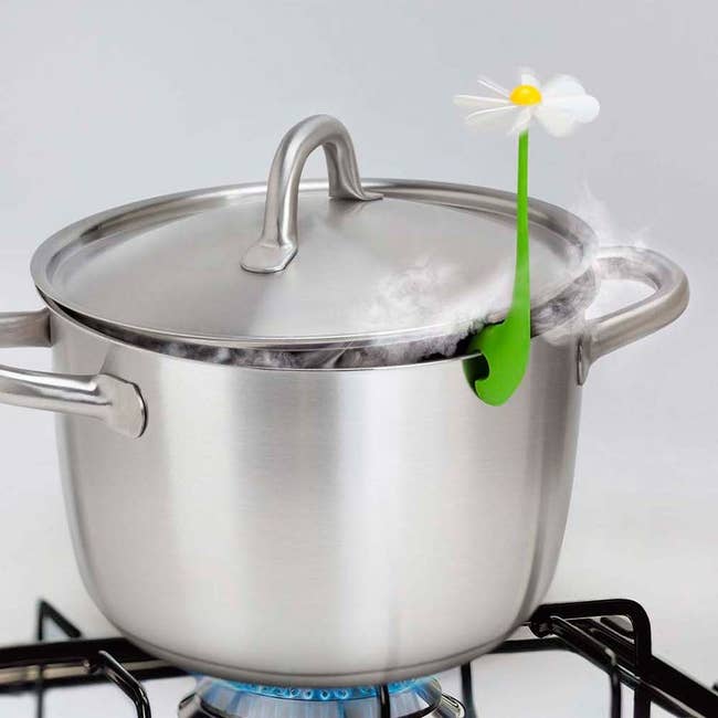 the flower-shaped steam releaser clipped onto a stainless steel pot